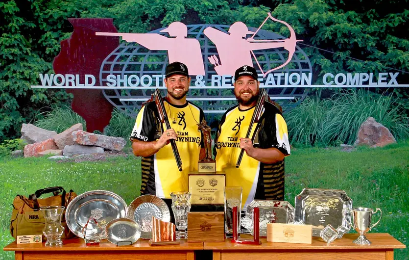 Matt and Foster Bartholow with shotguns and trophies from 2021 Grand American