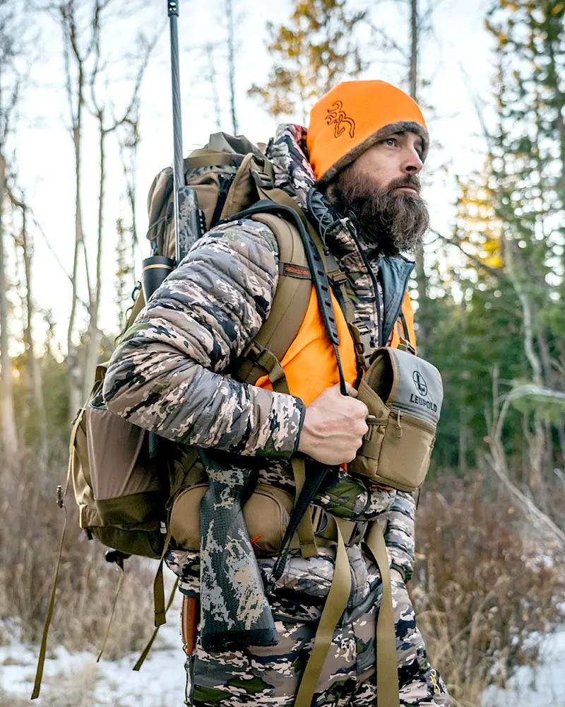 Hunter wearing OVIX camo and blaze in winter